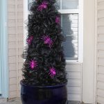 black halloween outdoor tree with witch legs at the bottom