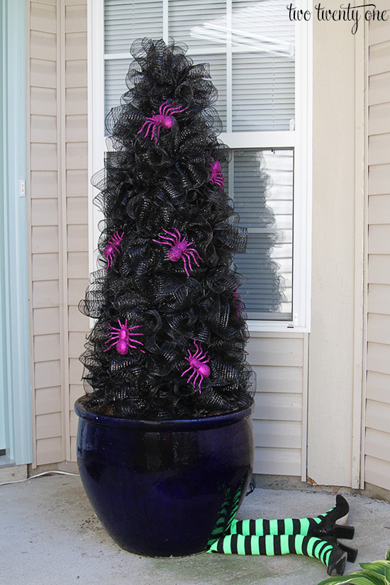 black halloween outdoor tree with witch legs at the bottom