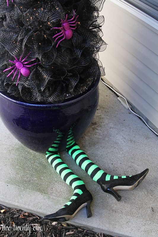 DIY witch legs sticking out from under planter with black Halloween tree