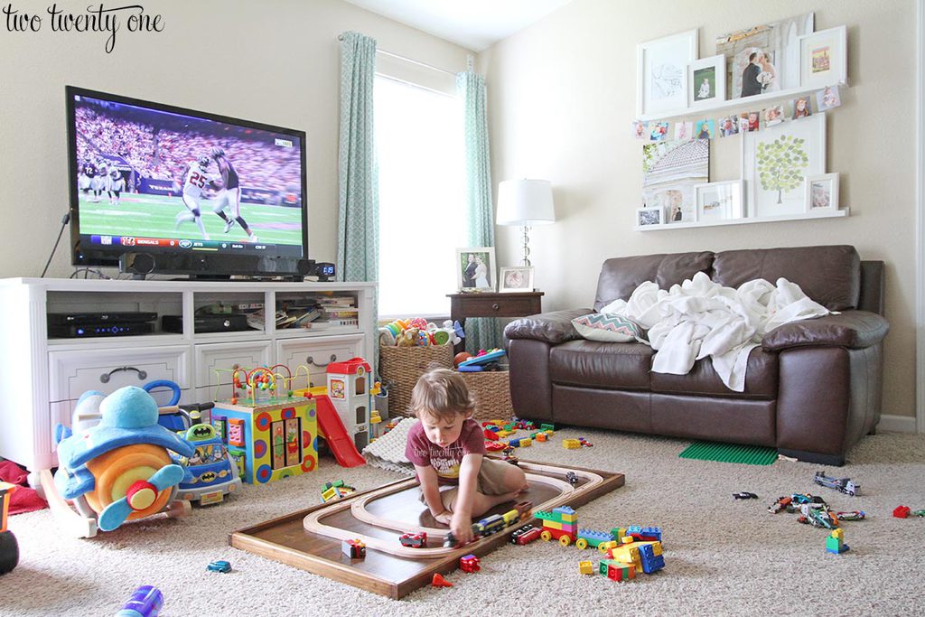 Is he in the living room. Messy Living Room. Living Room with Toys. Dirty Living Room. Living Room to describe.