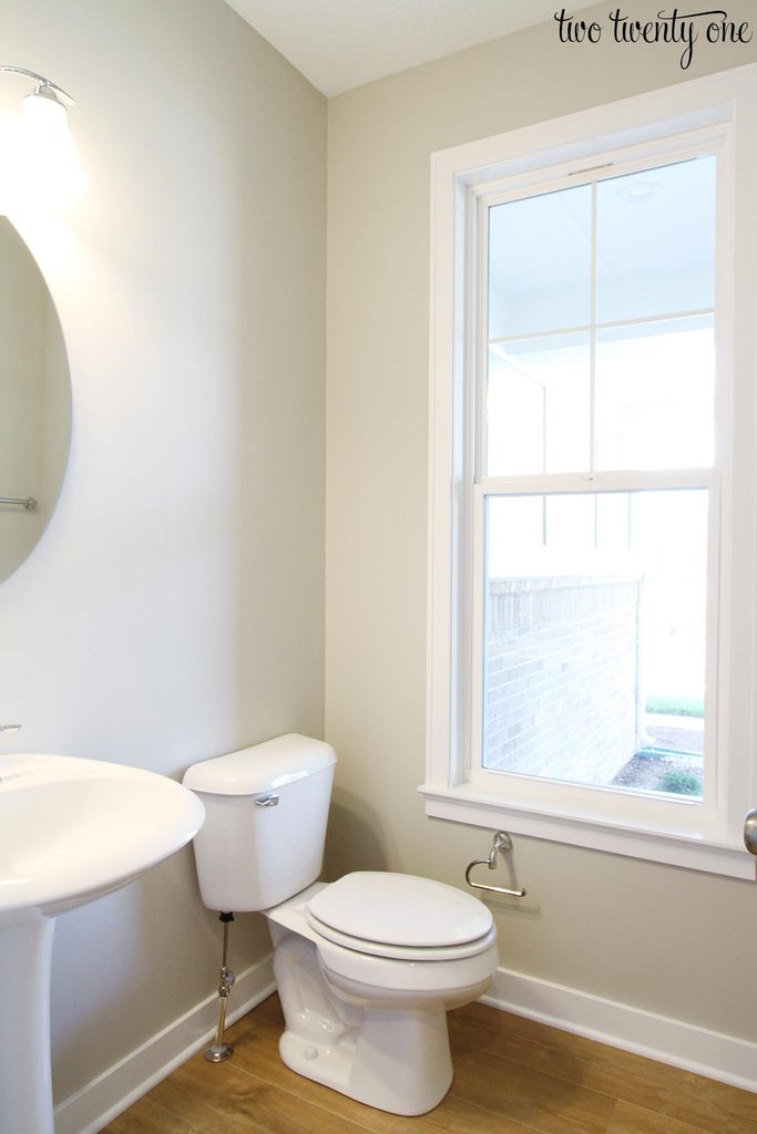 half bathroom with toilet, sink, and window