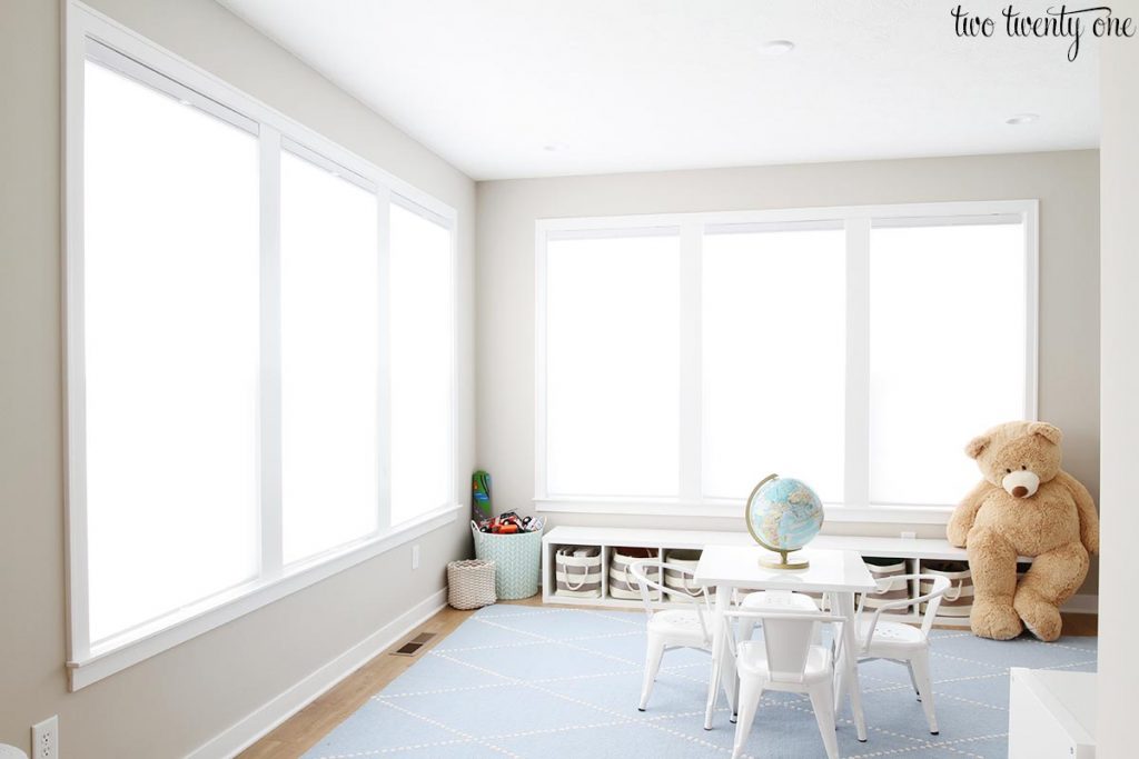 Playroom with Wordly Gray walls and Extra White trim. Light blue rug and two sets of three windows.