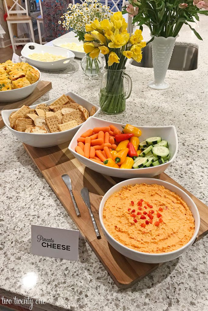 pimento cheese in a large bowl with bowls of vegetables and crackers