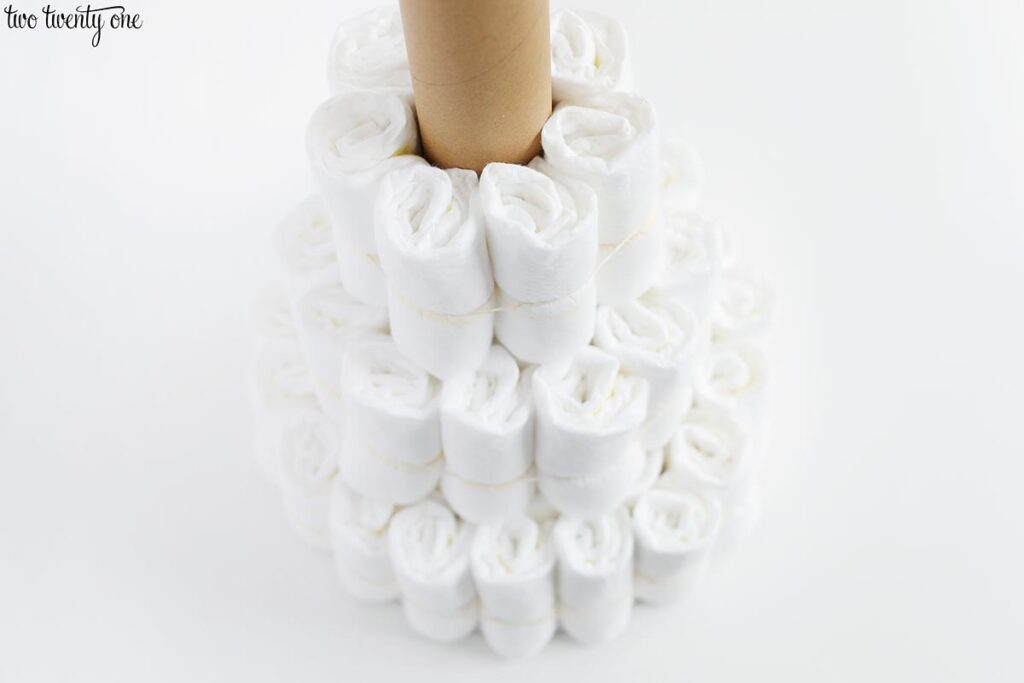 three tiers of rolled up diapers circling a cardboard tube