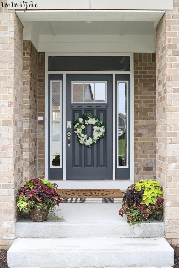 front porch with dark gray door and foliage planters