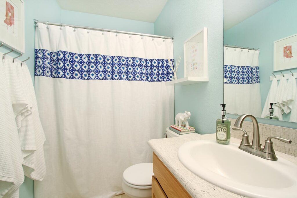 Sherwin Williams Tidewater in guest bathroom with white shower curtain