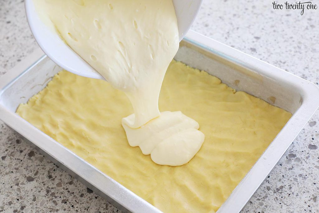 pouring cream cheese topping onto crust