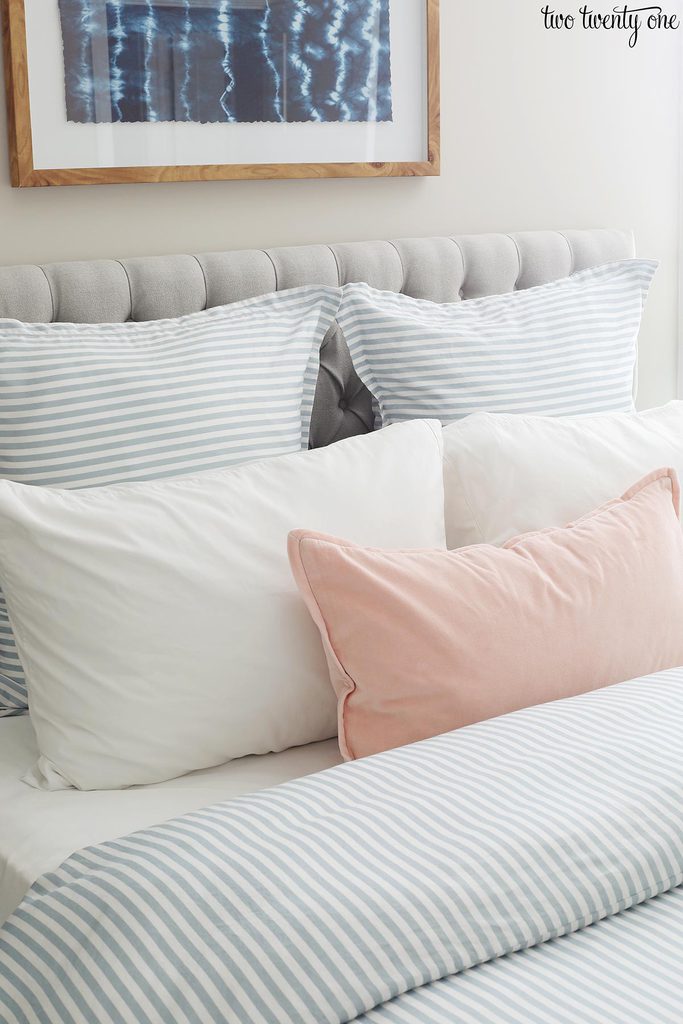 blue striped duvet cover with blue striped euro shams, white pillows, and a light pink pillow