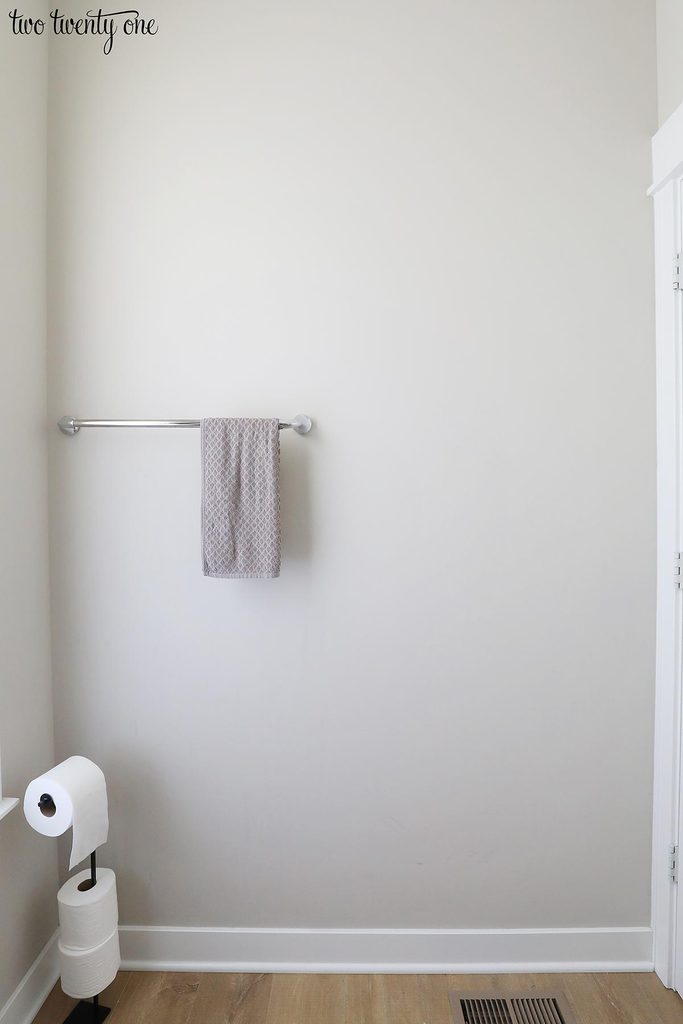 half bath with towel rack on wall and toilet paper holder