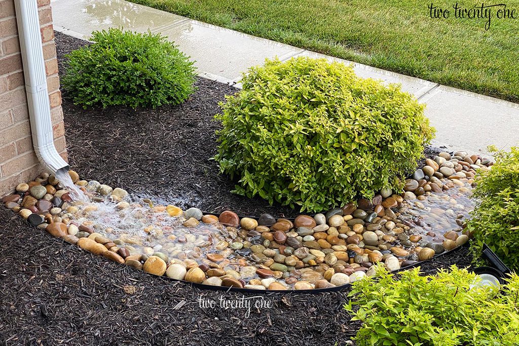 dry creek bed with rain water from downspout