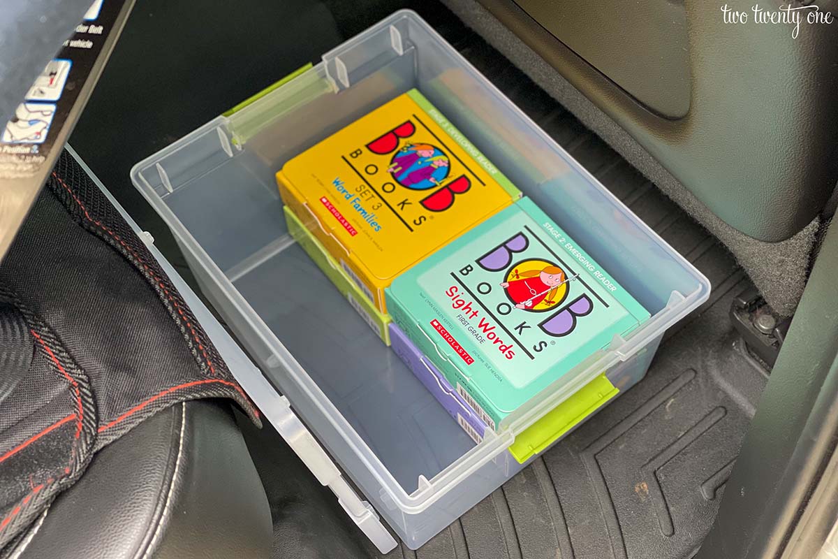 Four sets of BOB Books inside a plastic container with the lid off in a car.