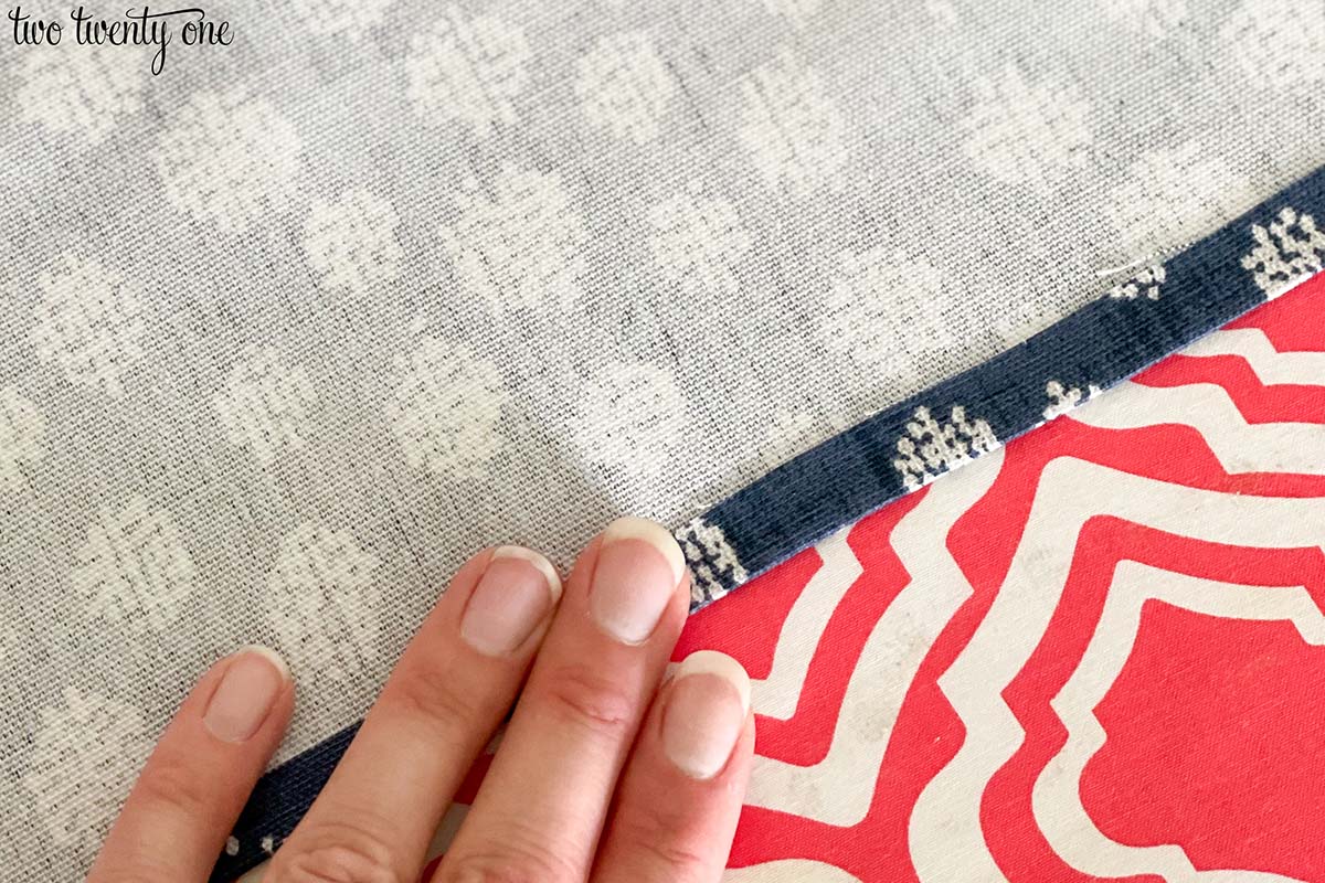 Hand pressing down on fabric hem