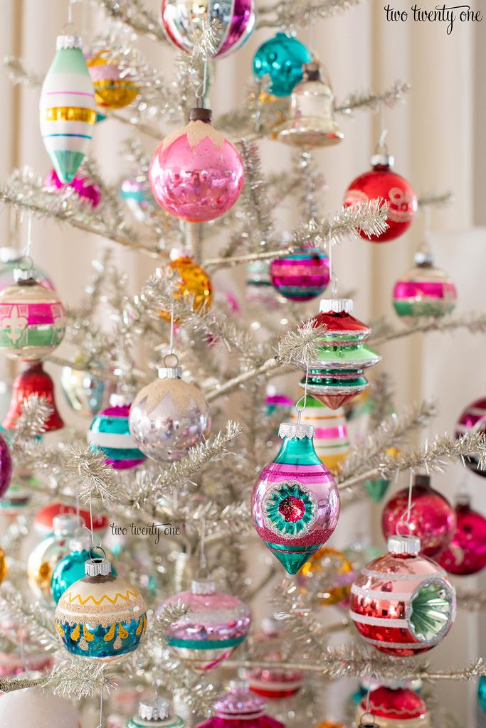 colorful glass ornaments on a silver tinsel christmas tree