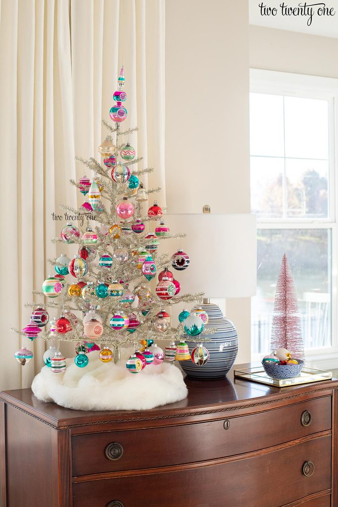 Tabletop silver tinsel Christmas tree with colorful glass ornaments 