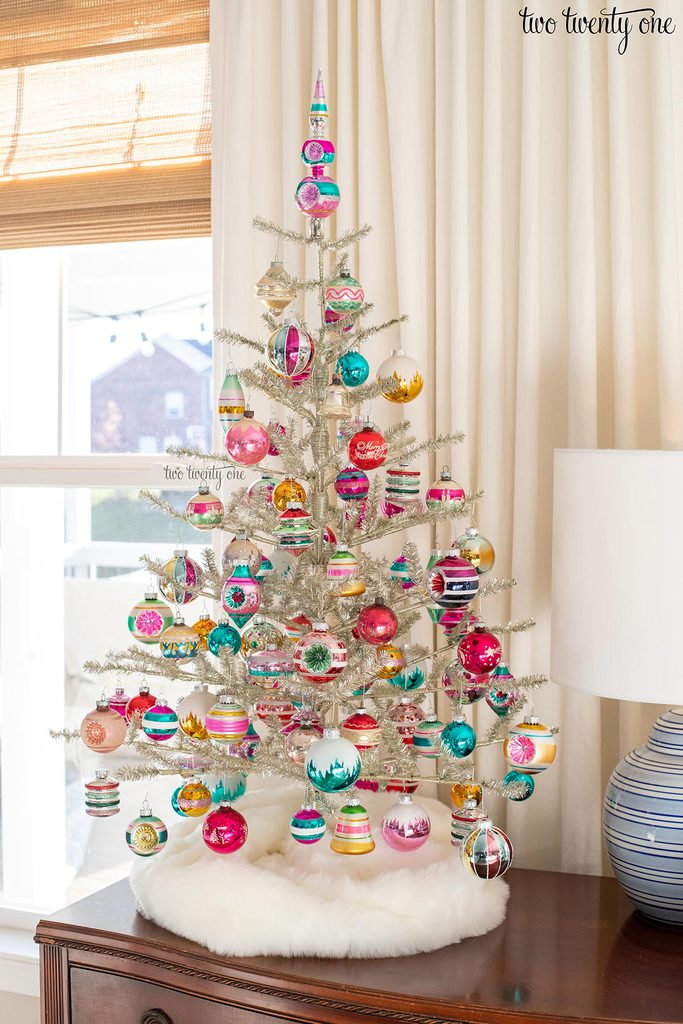 silver tinsel tabletop chrismtas tree decorated with colorful glass ornaments