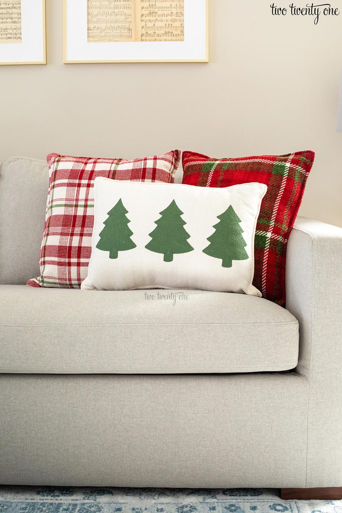 plaid holiday pillows and a pillow with green trees on it