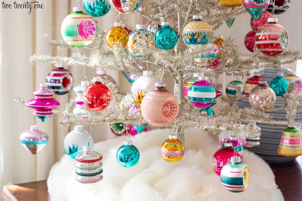 colorful glass ornaments on a silver tinsel christmas tree