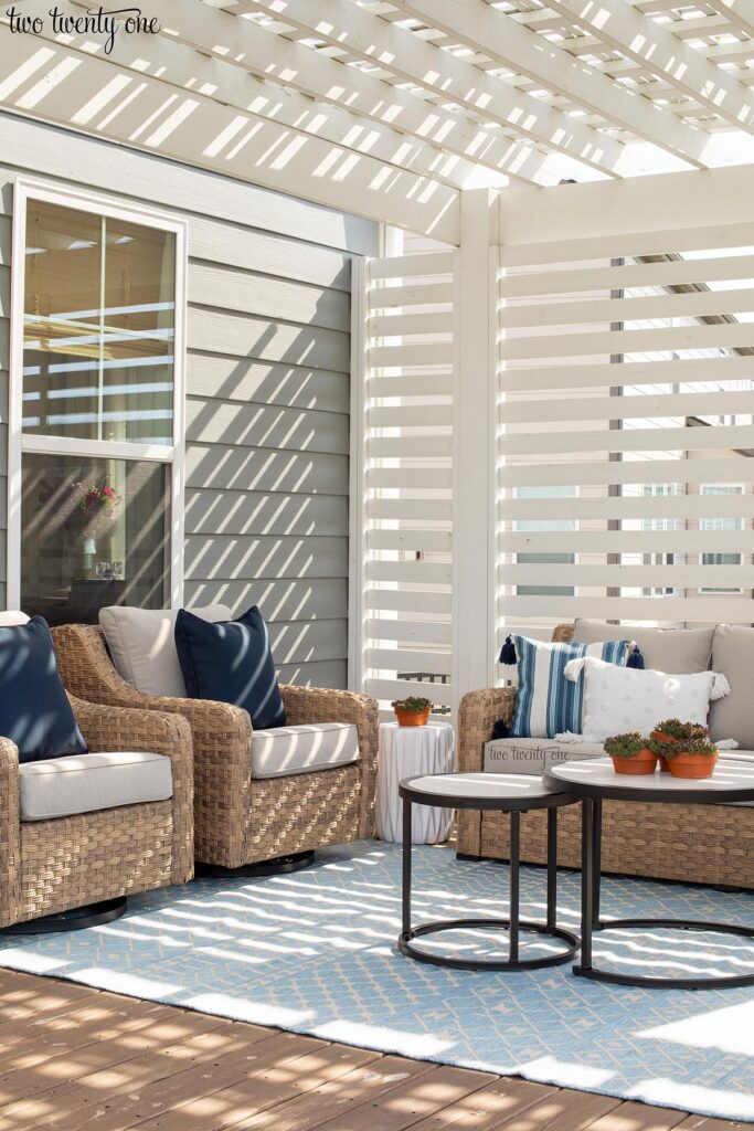 deck with two wicker rocker glider chairs and three seat sofa on a blue and white outdoor rug