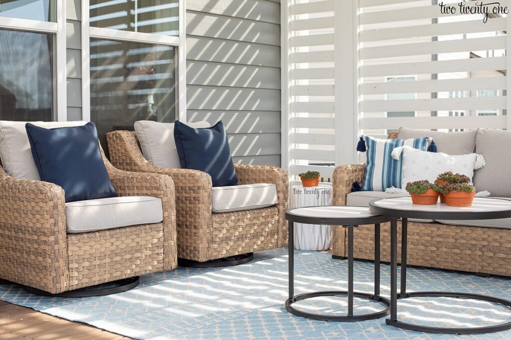 two wicker outdoor glider chairs on a blue and white rug