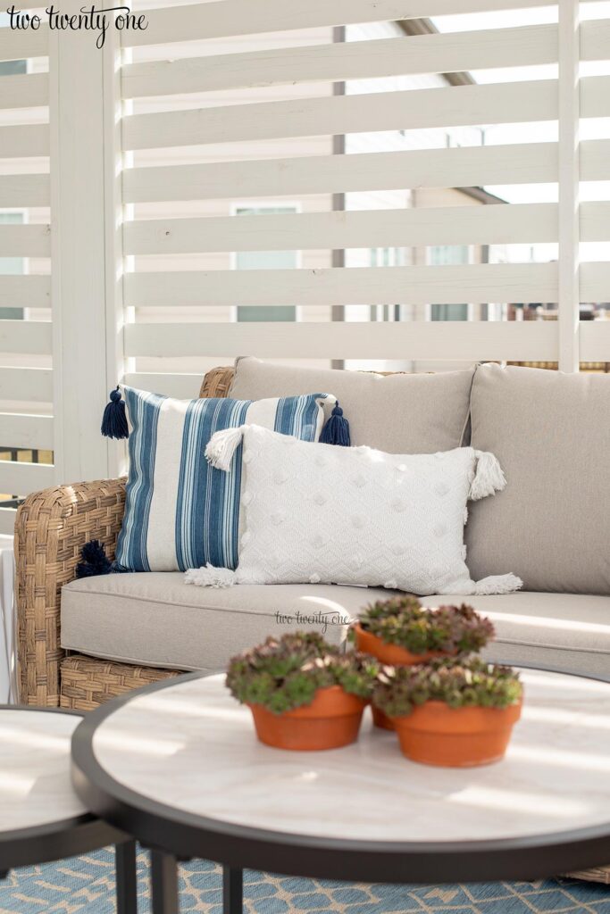 white and blue striped pillow and white textured pillow on an outdoor sofa