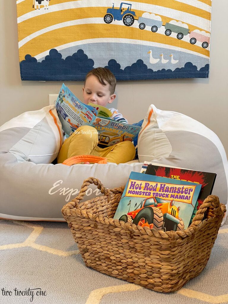 child reading a book while sitting in a stuffed boat 