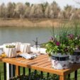 potting bench with small white planters, gardening gloves, and two flower pots on top