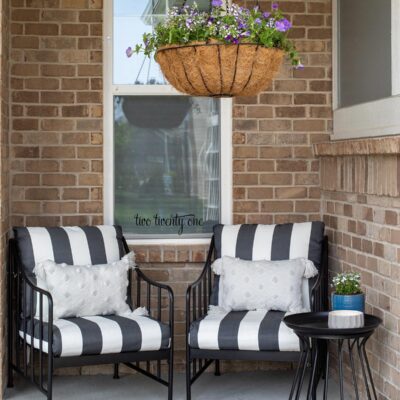 front porch with black and white patio furniture chairs and side table