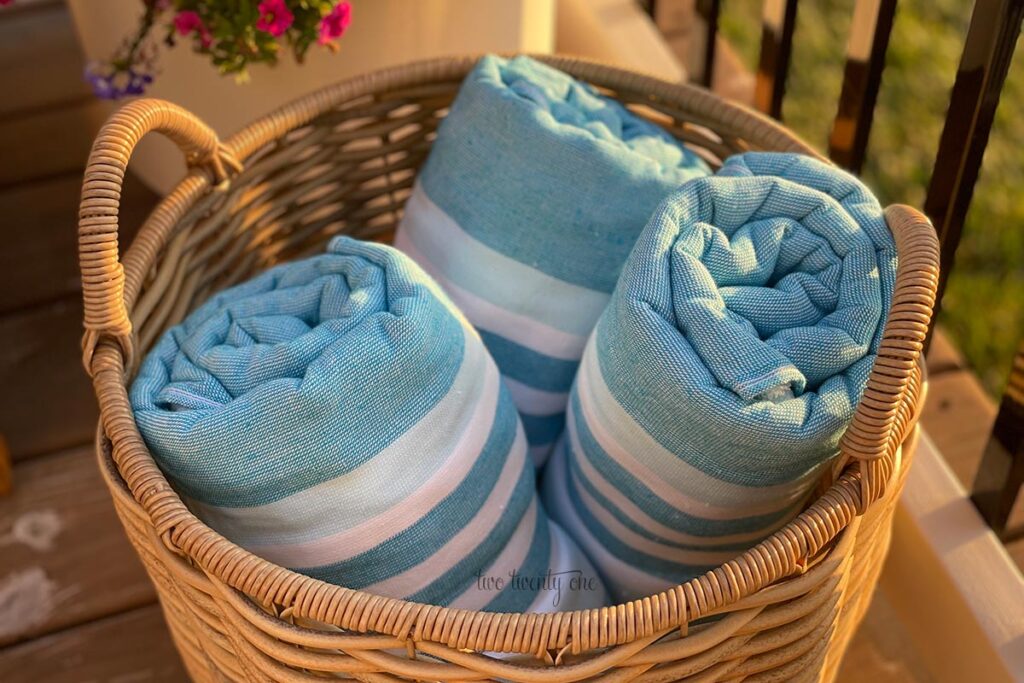 three blue and white striped towels in a woven basket