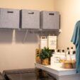 denim blue bins on a wire shelf in a laundry room