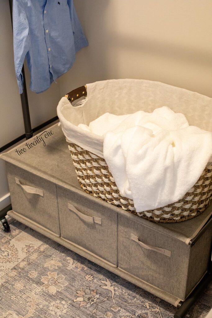 garment rack with storage and a basket with towels on top