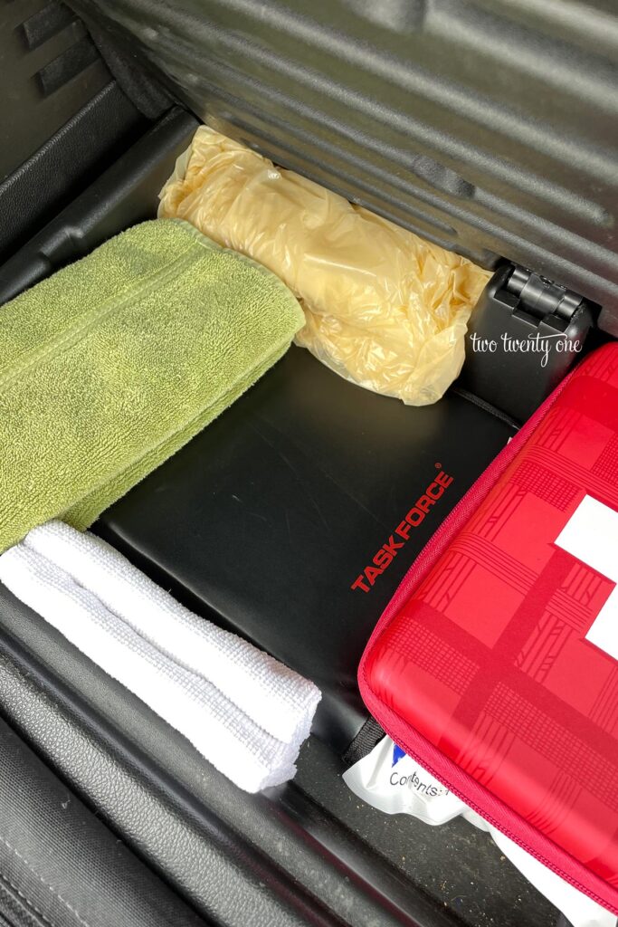 hidden car trunk compartment with tool kit, towels, first aid kit