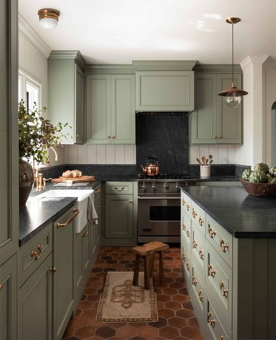 Kitchen with off-white walls and Benjamin Moore Oil Cloth painted cabinets. Counterops are soapstone and the floor is terra cotta hexagon tiles.