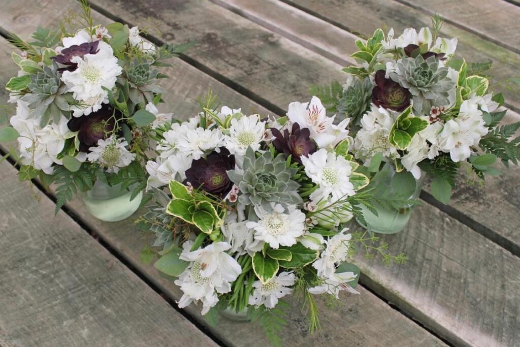 Three wedding centerpieces made with succulents from Costco.